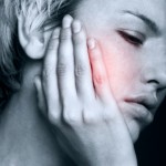 Young woman in pain is having toothache pain