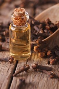 How to Stop Toothache Pain Fast: clove oil in a bottle of glass macro vertical